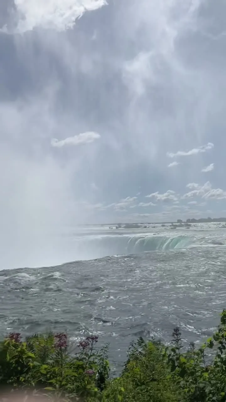 Water racing over the crest of the Horseshoe Falls at arm's length, mist rising