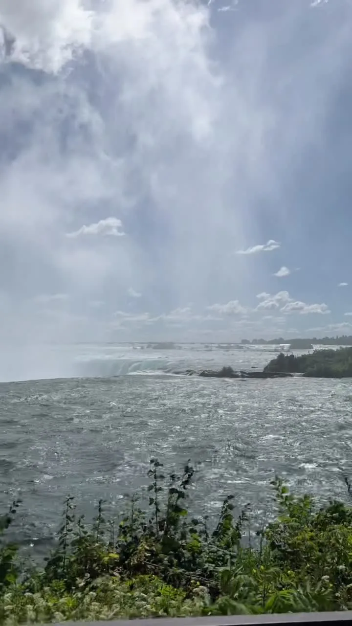 The river sliding toward the Horseshoe crest, railings and mist at the brink