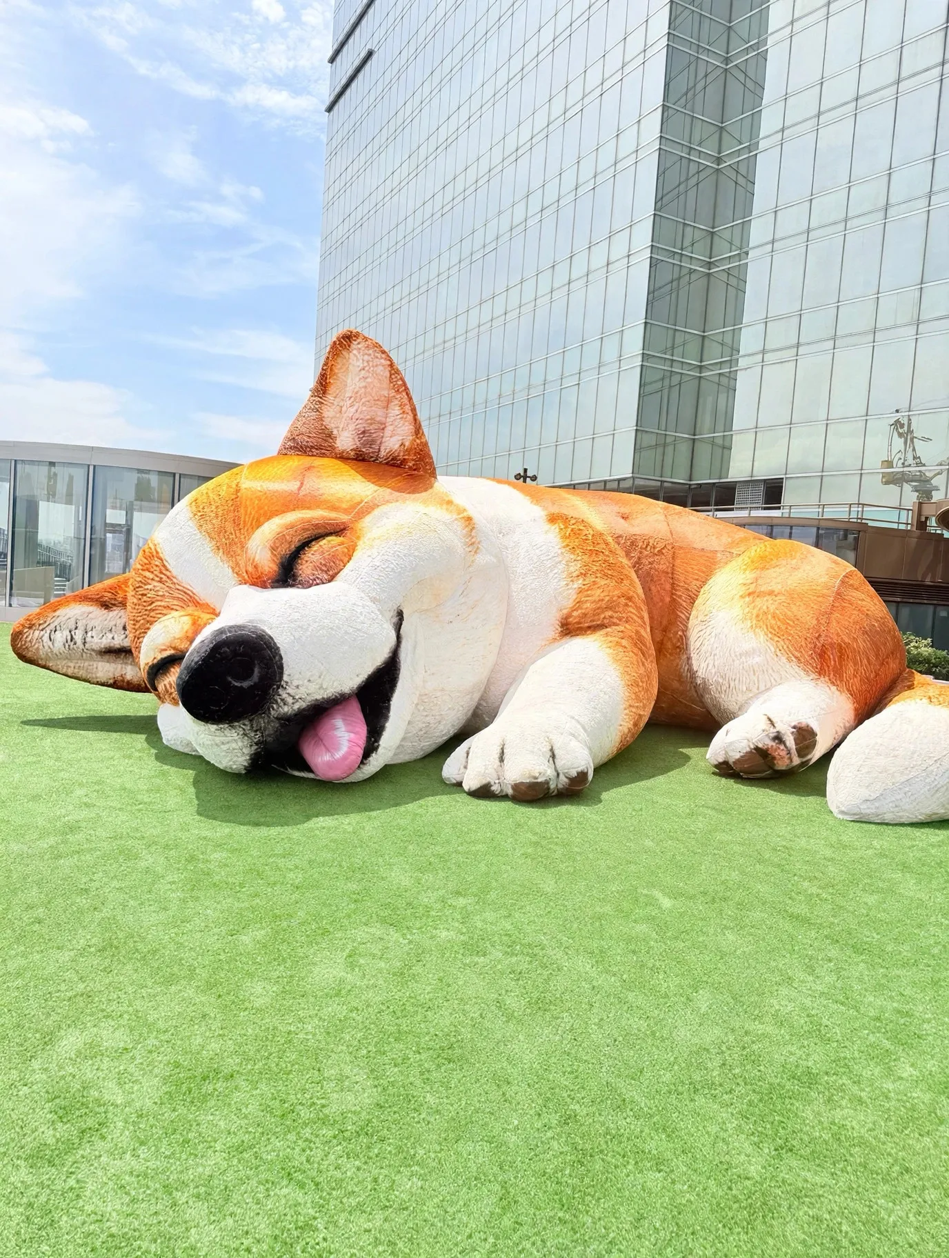 A giant sleeping Shiba sculpture on a lawn