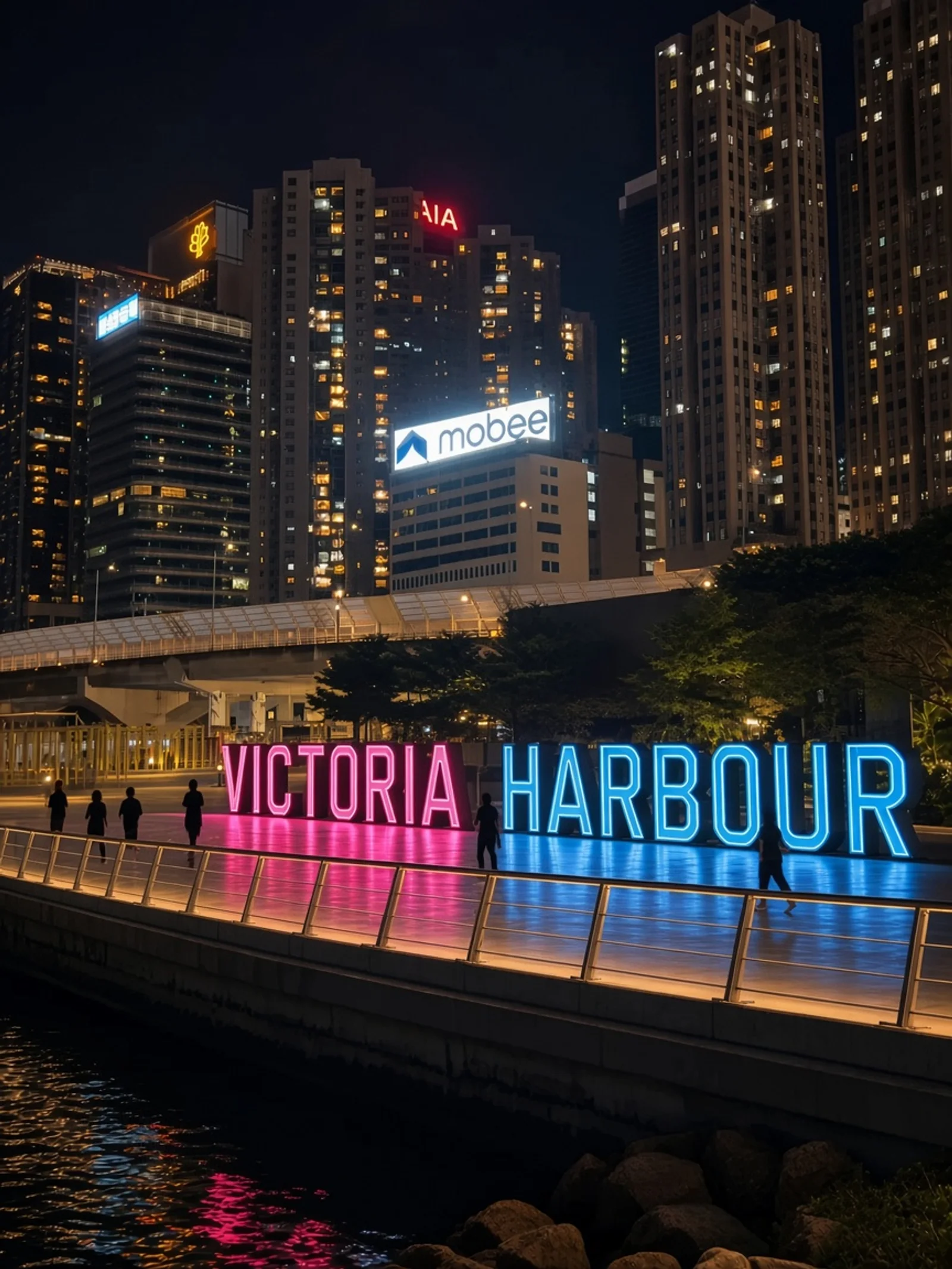 Letrero VICTORIA HARBOUR brillando de noche en el paseo