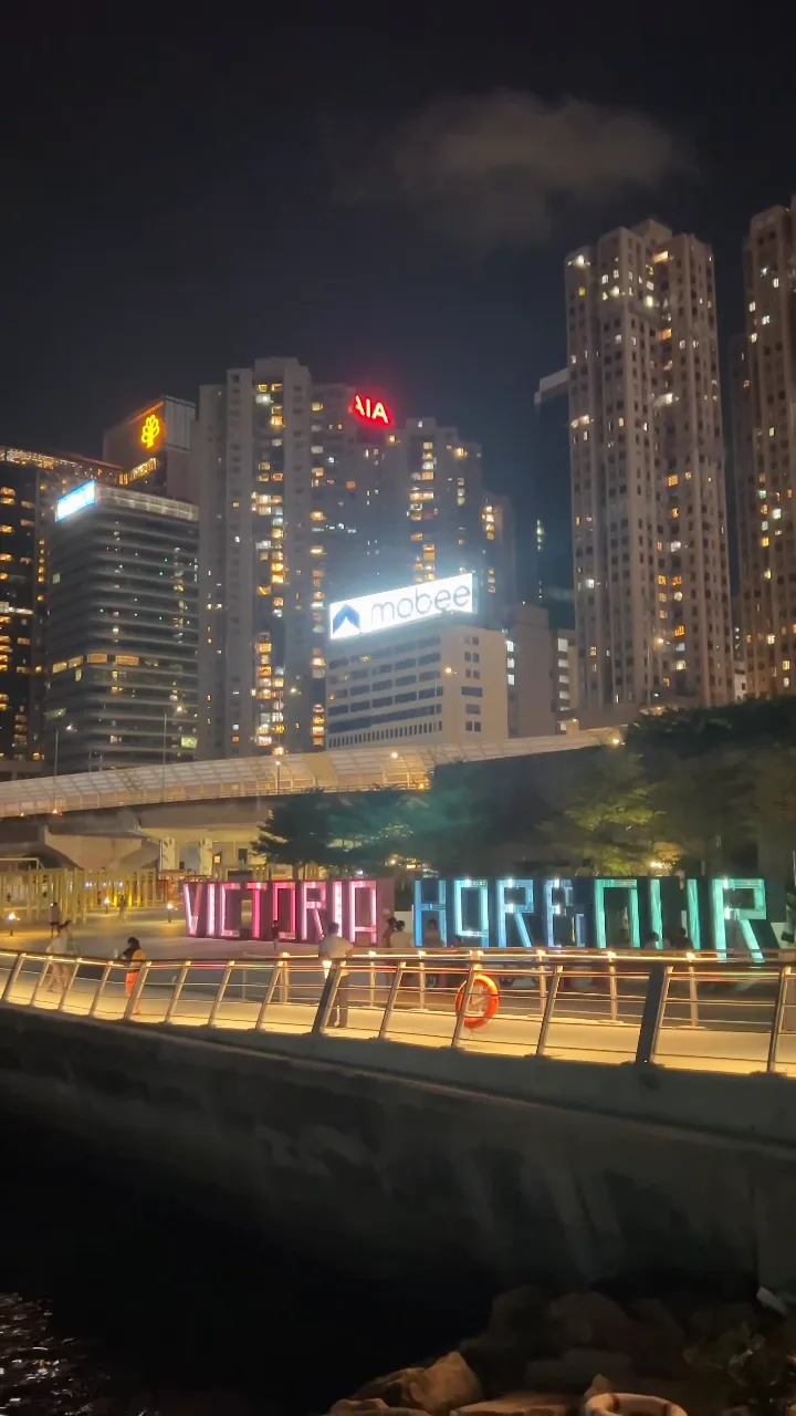 VICTORIA HARBOUR sign glowing at night on the waterfront