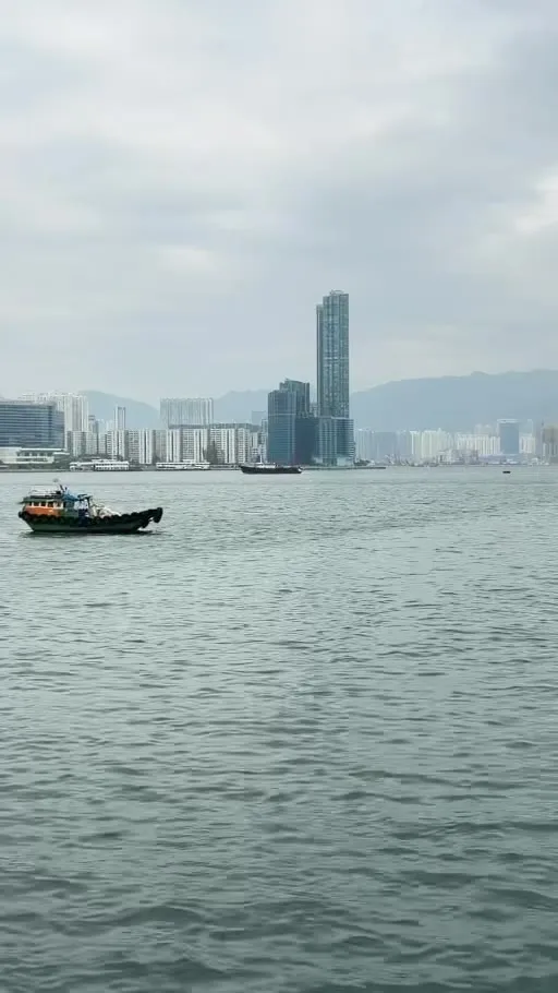 Boats on Victoria Harbour with towers on both shores