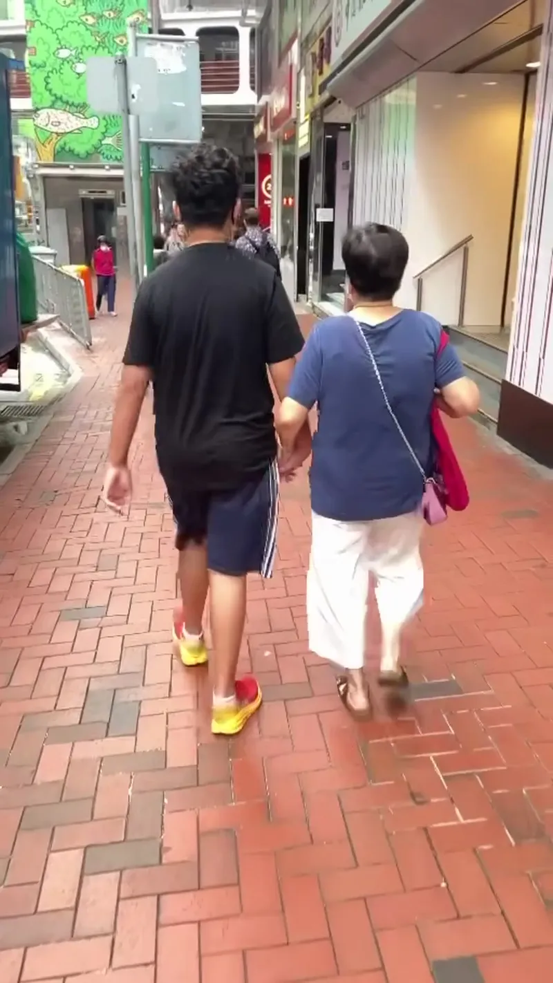 An adult and a child walking side by side on a brick pedestrian street