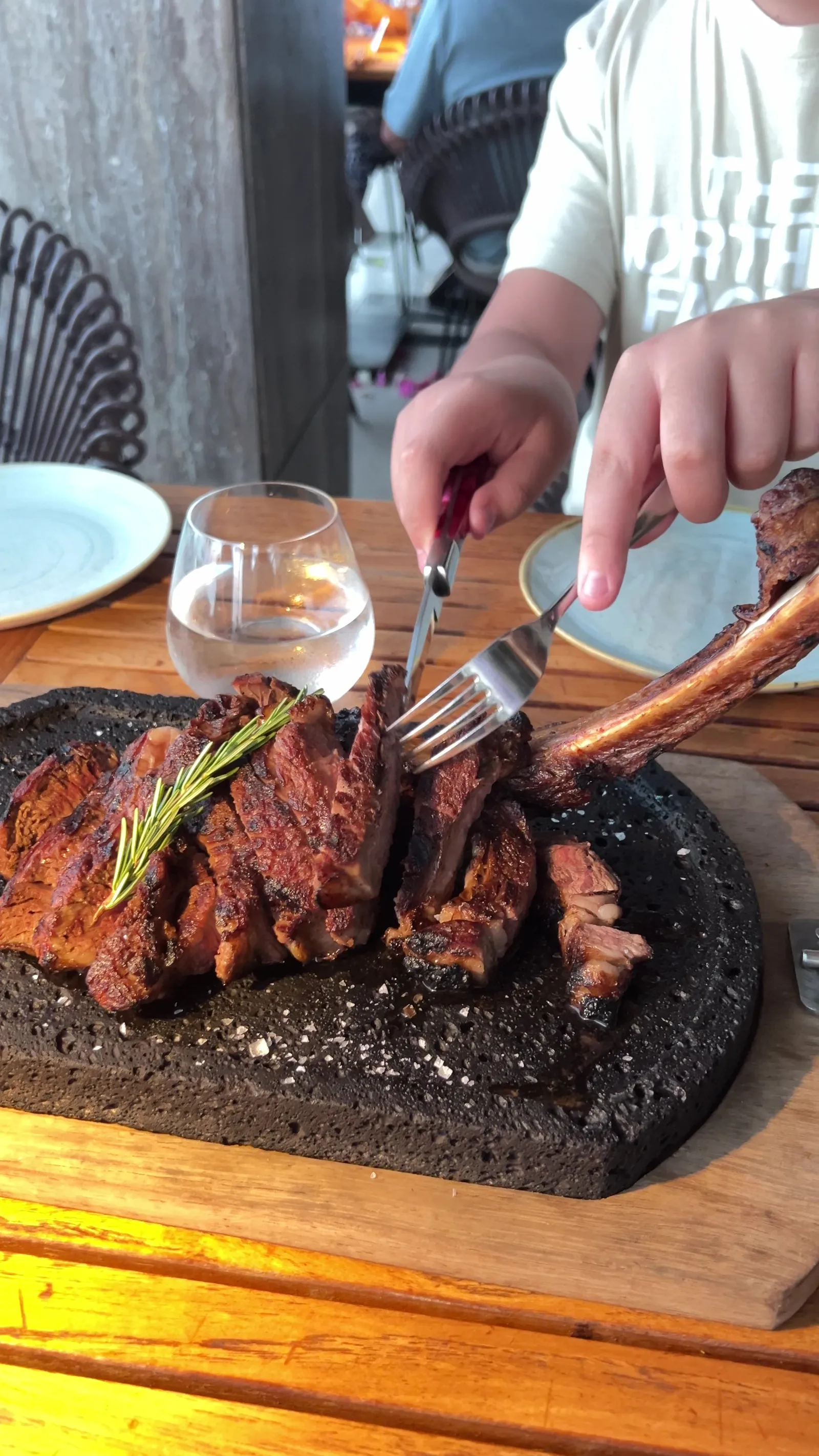 Tomahawk cortado en piedra negra sobre tabla de madera