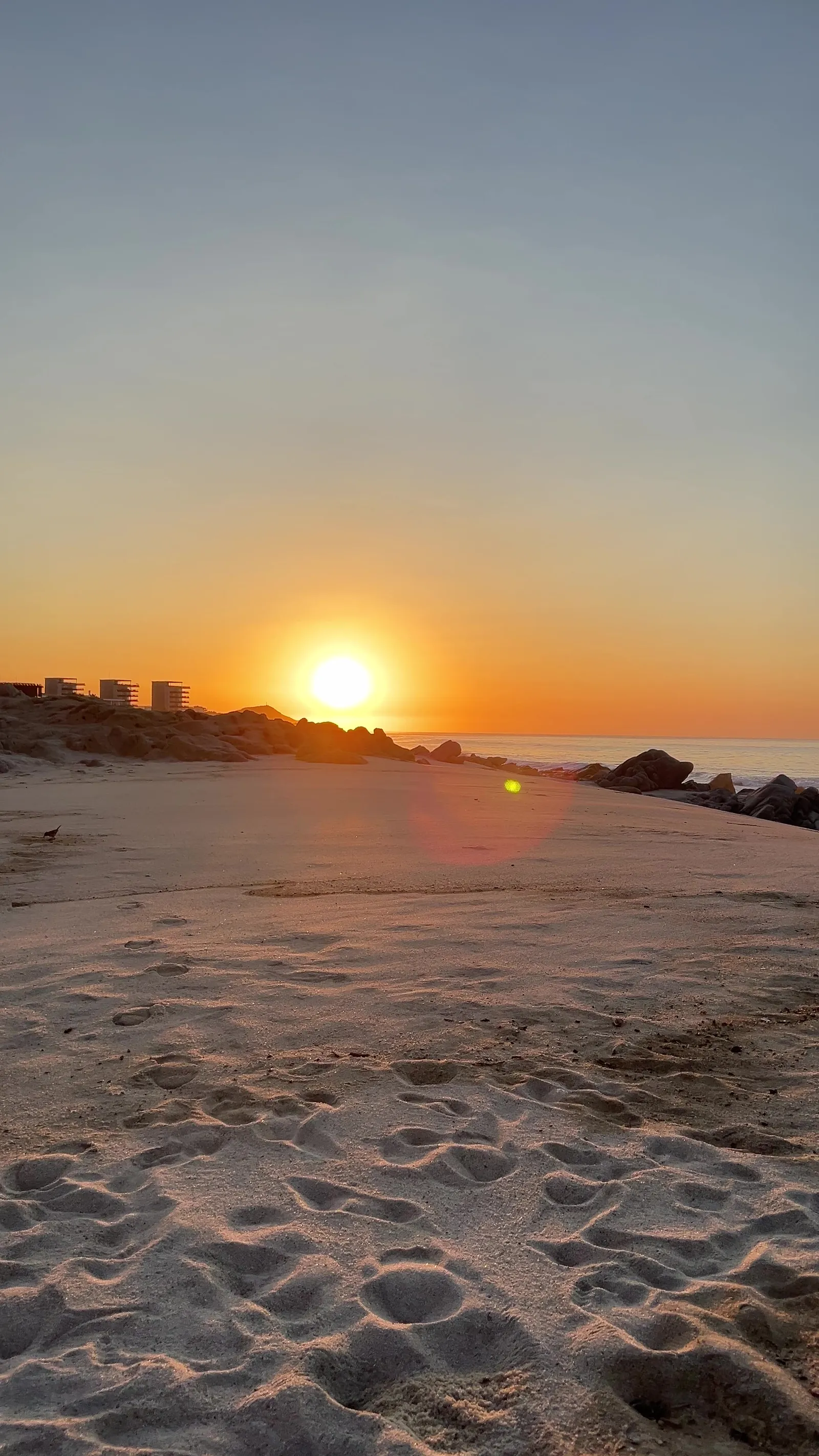 Sunrise over a Cabo San Lucas beach, footprints in the sand