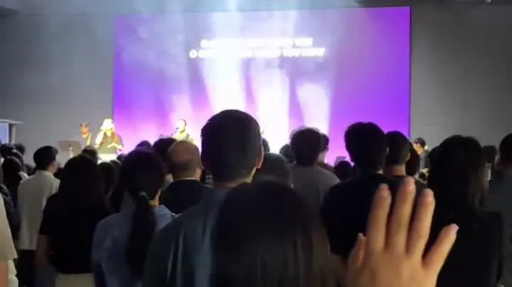 從最後一排望向發光螢幕的會眾,主日敬拜中