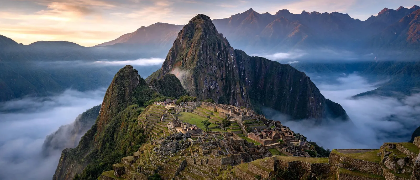 La ciudadela de Machu Picchu en la cresta al amanecer, niebla abajo