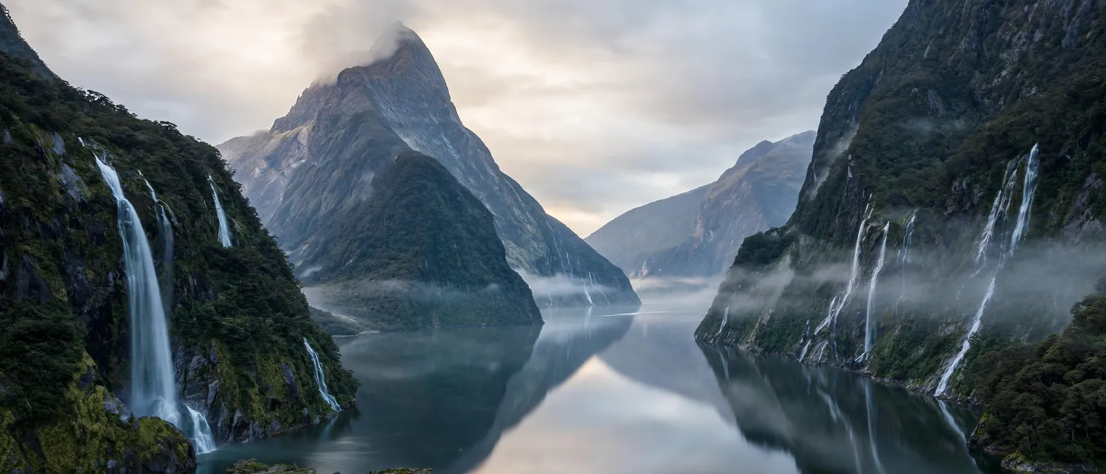 El fiordo de Milford Sound con acantilados y cascadas en la luz suave de la mañana
